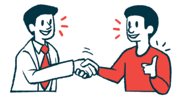A patient gives a thumbs-up sign while shaking hands with a doctor.