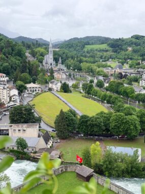 The esplanade is captured from a higher vantage point. It is expansive and green, and surrounded by centuries-old buildings. 